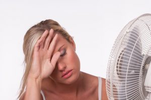 woman-in-front-of-fan-hand-on-head